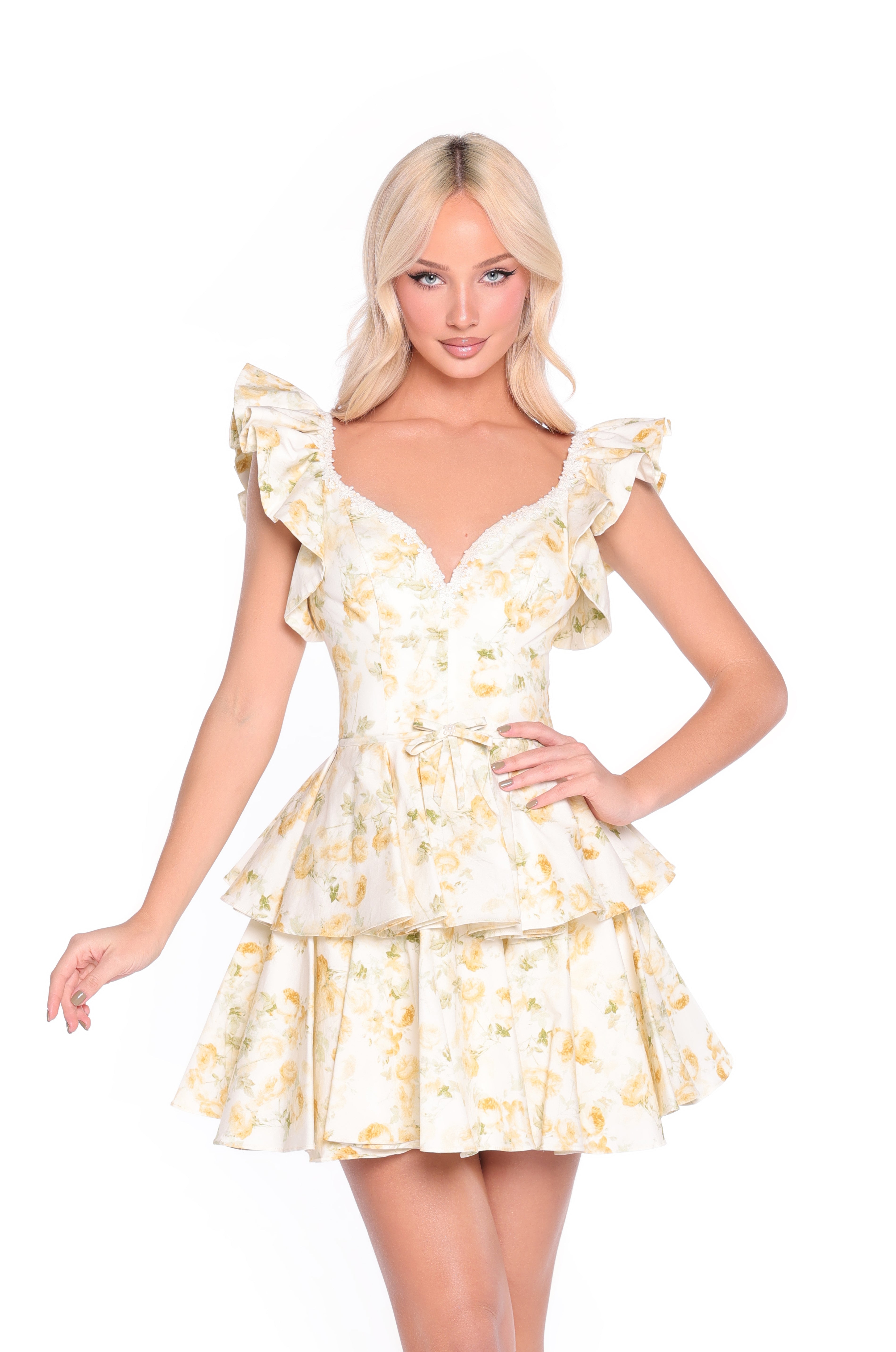 A blonde woman wears the Lourdes buttercream yellow floral mini sundress with ruffled sleeves, standing against a white background.